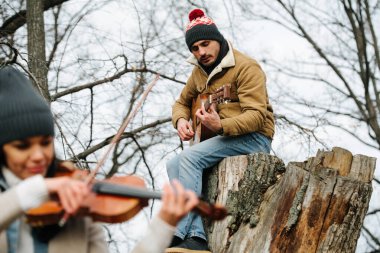 Güzel bir sonbahar ormanında bir kemancı ve gitaristin düeti