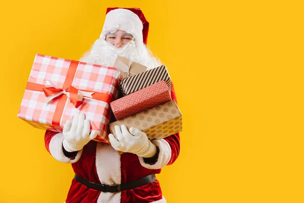 Feliz Papai Noel satisfeito com as mãos cheias de presentes — Fotografia de Stock