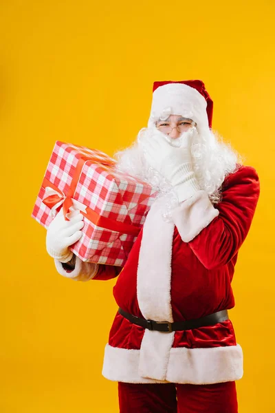 Feliz Papai Noel com um presente na mão acariciando sua barba . — Fotografia de Stock