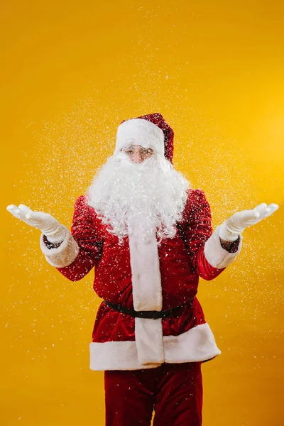 Weihnachtsmann zuckt mit den Schultern unter dem Schnee. über gelbem Hintergrund. — Stockfoto