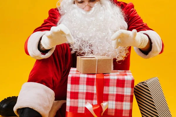 Papai Noel atando fitas em uma caixa com um presente — Fotografia de Stock