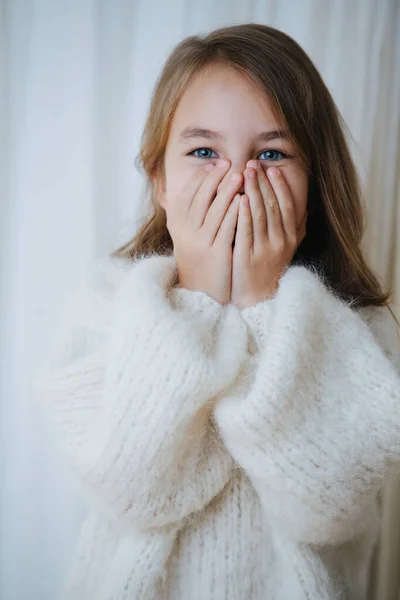 Retrato de una niña juguetona en blanco mullido suéter de punto que cubre la cara — Foto de Stock