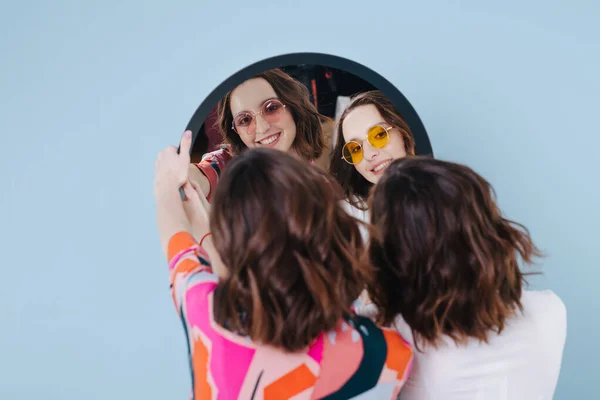 Twin sisters hold a mirror and we see their reflection — Stock Photo, Image