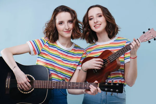 Two twin sisters play on guitar and ukulele together — Stock Photo, Image