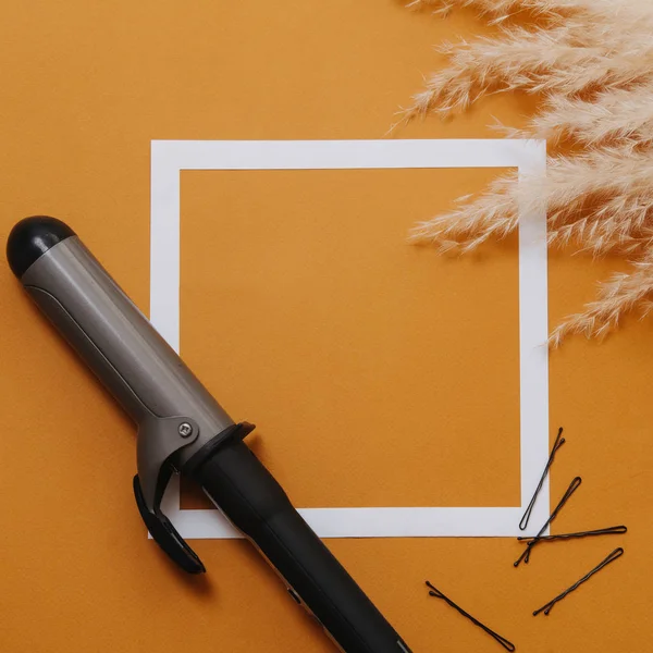 Hår verktyg: locktång och bobby stift över orange. Ovanifrån — Stockfoto
