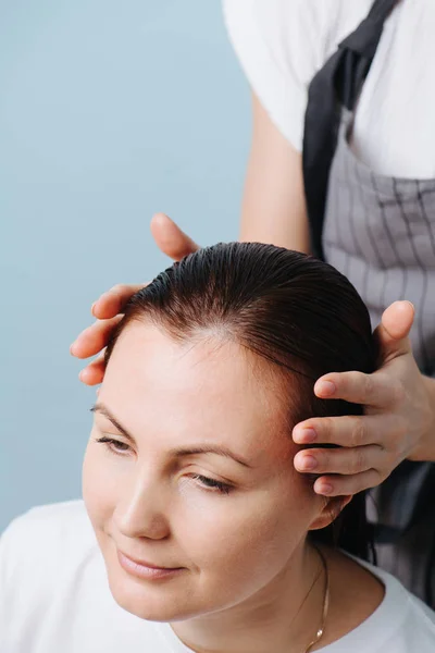 Cabeleireiro preparando o cabelo castanho elegante molhado do cliente para aparar . — Fotografia de Stock