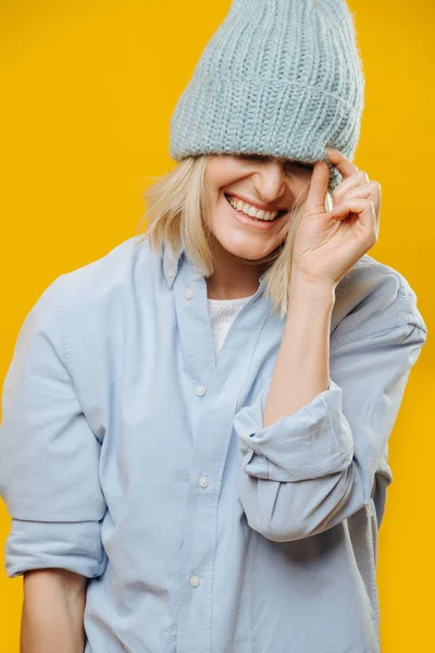 Смешная блондинка с голубыми часами на глазах на жёлтом фоне . — стоковое фото