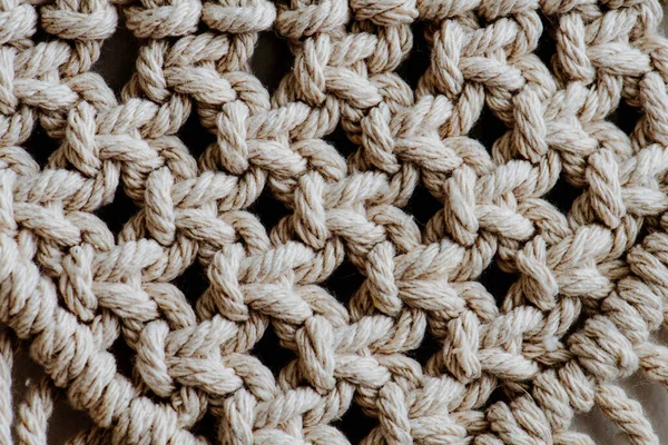 Nyílt szövésű makramé faliszőnyeg textúrája közelről. Csomók és kötelek egy mintában. — Stock Fotó