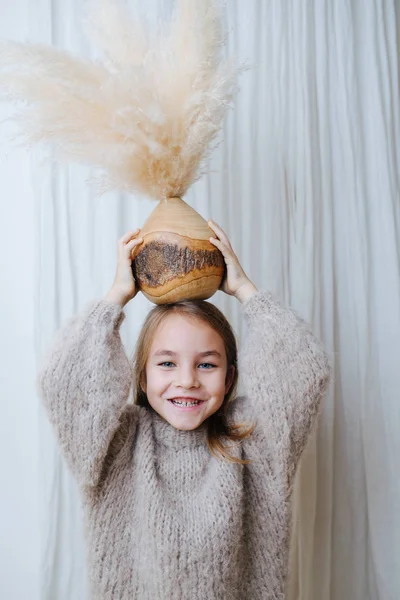 Menina segurando vaso de coco com buquê de cereais em cima da cabeça — Fotografia de Stock