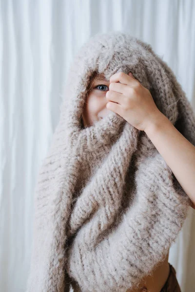 Little girl playing with sweater, she pulled it over head, peeking from hole — Stock Photo, Image