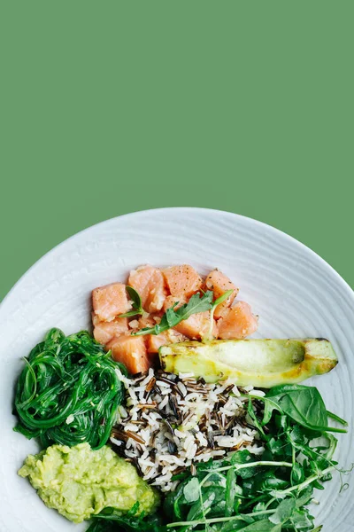 Gezond meel: gezouten zalm met avocado, spinazie, zeewier en bruine rijst — Stockfoto