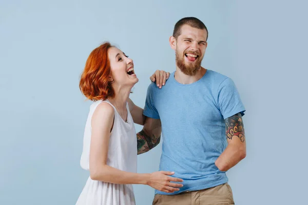 Feliz pareja en casa riendo en voz alta sobre fondo azul . — Foto de Stock
