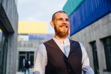 Kolsuz ceketli mutlu adam gün batımında dar sokakta yürüyor.