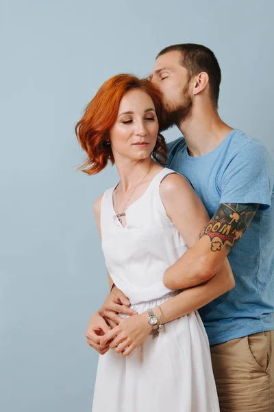 Feliz pareja enamorada abrazándose en casa sobre fondo azul . — Foto de Stock