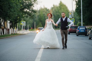 Gelin ve damat caddenin ortasında birlikte yürüyorlar.