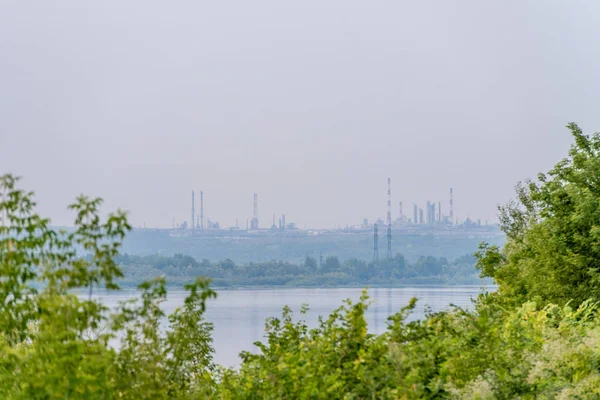 Ufuk çizgisinde nehrin karşısındaki sanayi bölgesinin uzak görüntüsü.