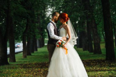 Gelin ve damat birlikte karanlık bir sokakta alınlarına dokunuyorlar.