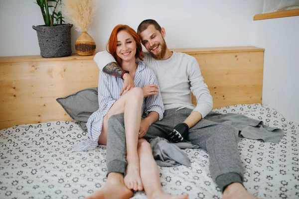 Casal feliz casal refrigeração em uma cama de casal em casa — Fotografia de Stock