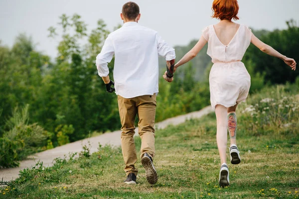 手で公園の手に沿って実行して幸せな結婚した中年のカップル — ストック写真