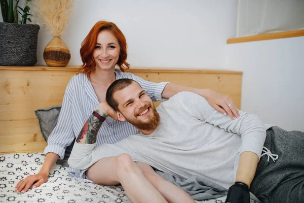 Mutlu evli çift evde çift kişilik yatakta dinleniyor. Fotoğraf için poz vermek. — Stok fotoğraf