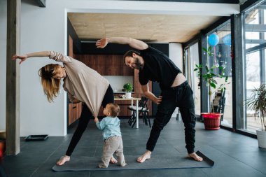 Anne ve baba çocuklarıyla vakit geçirirken sabah egzersizi yapıyorlar.