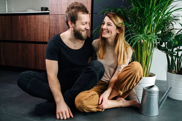 Mutlu çift, saksıların yanında, saksıları ve sulama kutuları olan yerde oturuyor. — Stok fotoğraf