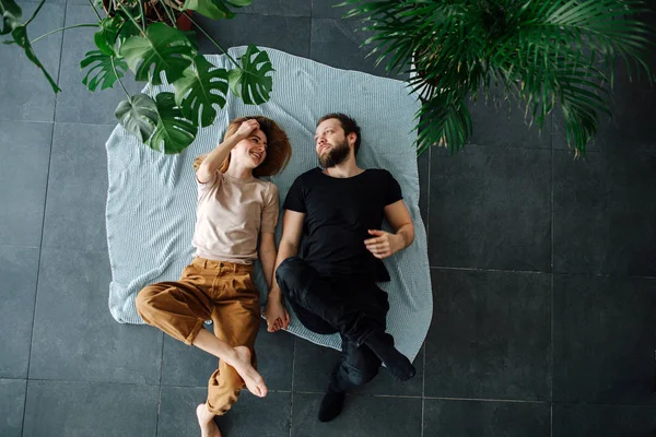 幸せなカップルの横にある床にシーツで覆われた上に横に横たわる。. — ストック写真