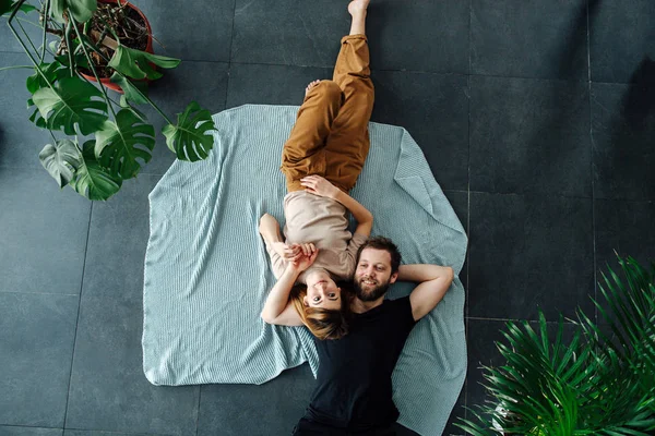 Vista superior de una feliz pareja acostada en el suelo cabeza a cabeza —  Fotos de Stock