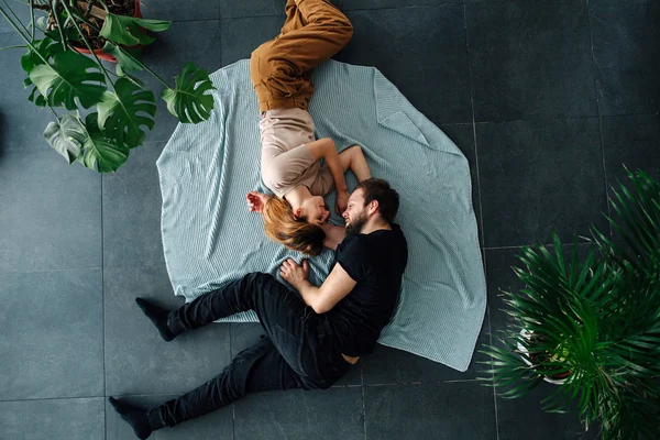 Два влюбленных человека лежат лицом к лицу на полу, свернувшись — стоковое фото