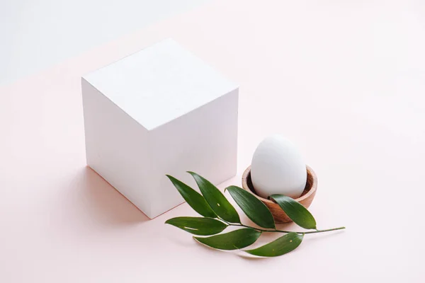 Dekoratif Beyaz Küp Yumurta Ahşap Bir Tabakta Yapraklarla Süslenmiş Pastel — Stok fotoğraf