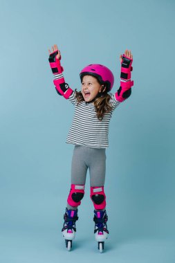 O, paten kaymayı sever. Duygusal genç kız paten üzerinde dururken sevinçten ellerini kaldırdı..