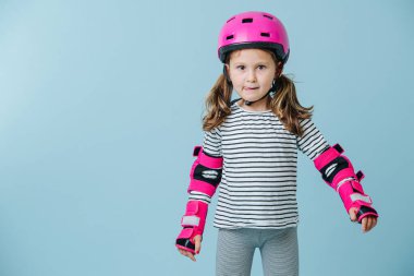 Dili sarkık, çalışkan bir genç kızın portresi. Paten yaparken koruyucu kol büzgüleri ve kask takıyor..