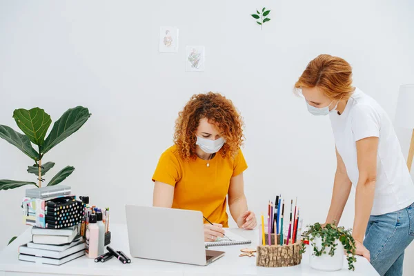 Dos chicas de pelo rojo detrás del proceso creativo en máscaras médicas protectoras —  Fotos de Stock