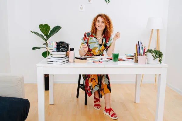 Ragazza di professione creativa, posa seduta a un tavolo — Foto Stock