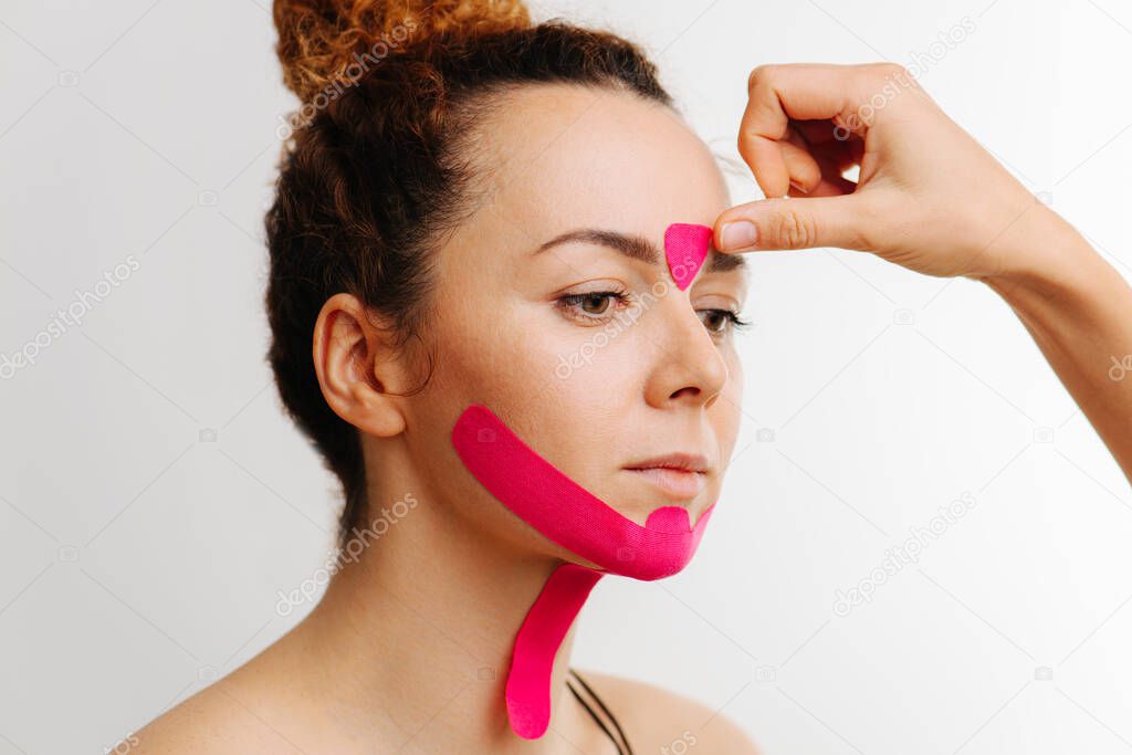 Close-up portrait of girl, sticking to the face cosmetic tape