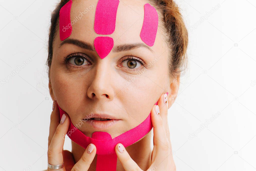 close-up of a girls face with cosmetological pink anti-wrinkle tape
