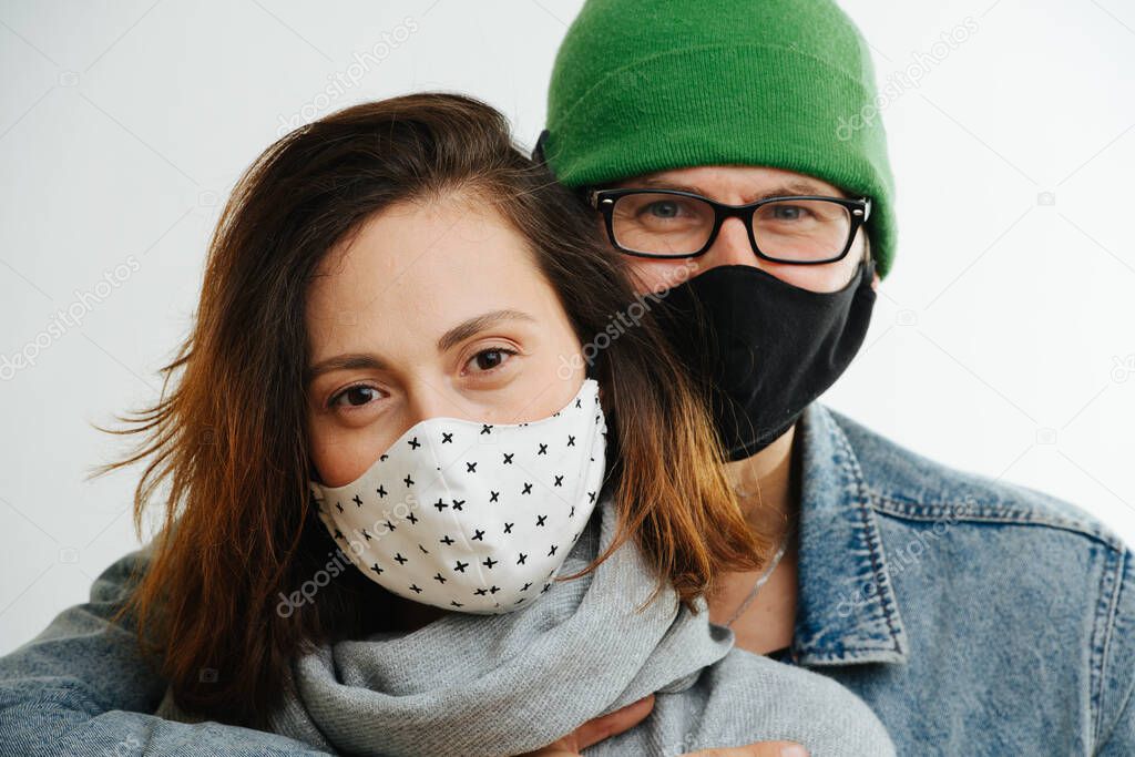Close-up portrait of young couple quarantined in protective masks