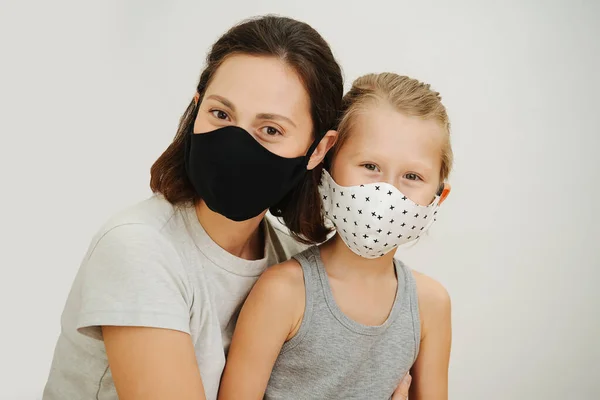 Beyaz arka planda koruyucu maskeli anne ve oğlunun portresi