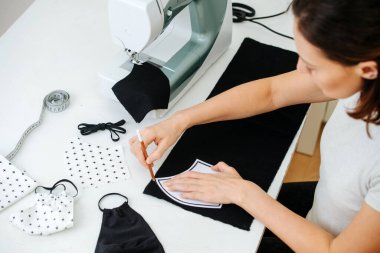 Bir kız evde çalışıyor. Dikiş makinesinin arkasında baştan çıkarıcı bir şeyler yapıyor.