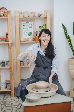 Middle Age esmer kadın özel atölyesinde çömlek çarkında killi kase şekillendiriyor. İzolasyon sırasında hobisi üzerinde zaman geçirme şansı..