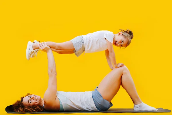 Moeder Dochter Gimnastic Vormen Een Yoga Mat Gele Achtergrond Meisje — Stockfoto