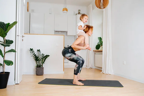 Young Mother Working Out Home Isolation She Doing Squats Toddler — Stock Photo, Image
