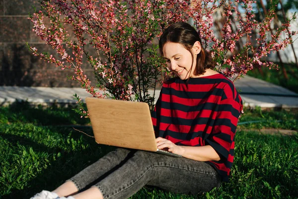 Feliz Joven Sentada Césped Con Portátil Bajo Suave Sol Primavera — Foto de Stock