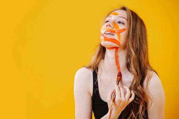 Menina bonita aleatoriamente pintando em seu rosto e pescoço — Fotografia de Stock