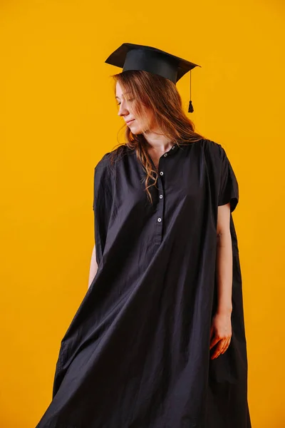 Женщина в выпускном платье и шляпе на оранжевом фоне . — стоковое фото