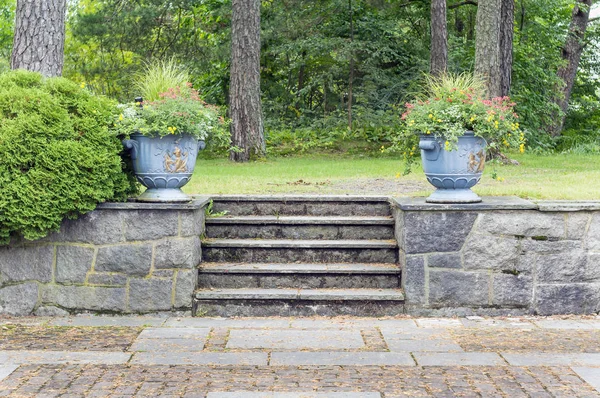 Two big flowerpots with flowers near the stairs in a Sandefjord