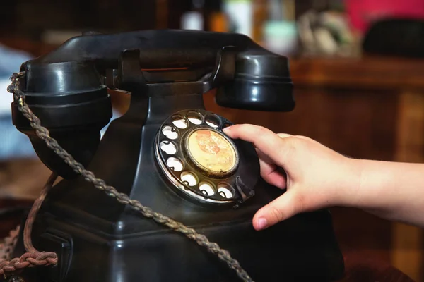 Child finger turning an old black vintage phone — Stock Photo, Image