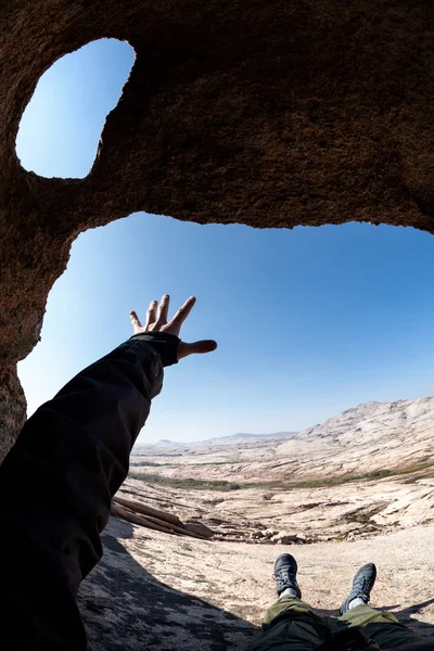 Mann streckt seine Hand in der Wüstenhöhle aus — Stockfoto