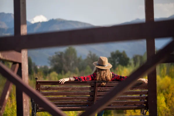 Frau mit Hut auf der Bank — Stockfoto