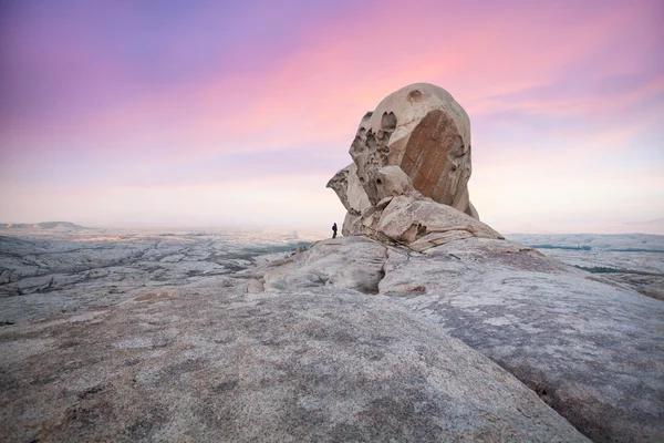 Homem na frente de uma grande rocha no deserto de pedra — Fotografia de Stock